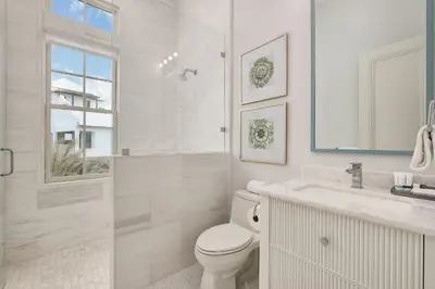 a white bathroom with a toilet and a sink at Seaclusion at Seagrove in Santa Rosa Beach