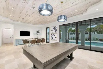 a dining room with a table and a television at Seaclusion at Seagrove in Santa Rosa Beach
