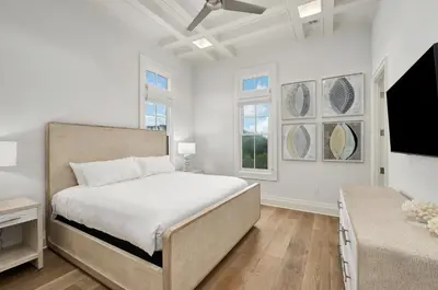 a bedroom with a bed and a flat screen tv at Seaclusion at Seagrove in Santa Rosa Beach