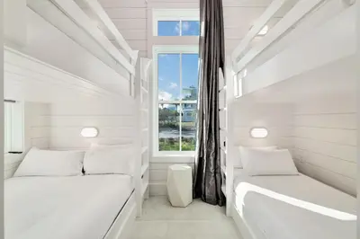 two beds in a white room with a window at Emerald Palms in Inlet Beach