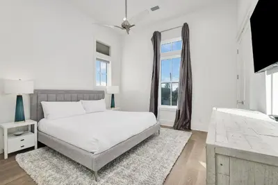 a white bedroom with a bed and a window at Emerald Palms in Inlet Beach