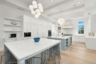 a kitchen with white cabinets and a large white island at Sanctuary at Seagrove in Santa Rosa Beach