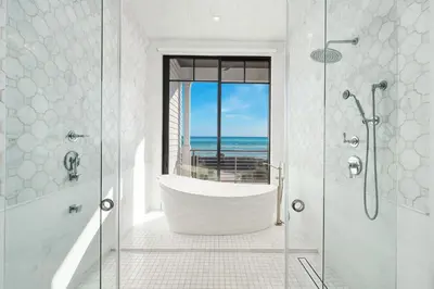 a bathroom with a tub and a shower with a view of the ocean at Sanctuary at Seagrove in Santa Rosa Beach