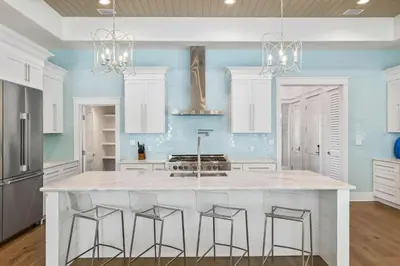 a kitchen with a large white island with bar stools at Casa al Mare in Santa Rosa Beach