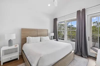 a white bedroom with a large bed and a window at Casa al Mare in Santa Rosa Beach