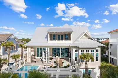 a white house with a pool and palm trees at Seagrove Sparrow in Santa Rosa Beach
