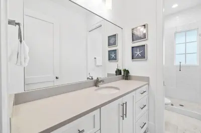 a white bathroom with a sink and a mirror at Seagrove Sparrow in Santa Rosa Beach