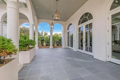 an empty hallway of a home with columns and windows at Soleil at Seagrove in Santa Rosa Beach