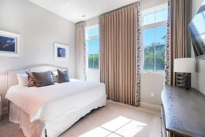 a white bedroom with a bed and a window at Soleil at Seagrove in Santa Rosa Beach