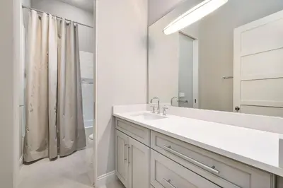a white bathroom with a sink and a mirror at Soleil at Seagrove in Santa Rosa Beach