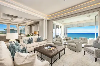 a living room with white furniture and a view of the ocean at Soleil at Seagrove in Santa Rosa Beach