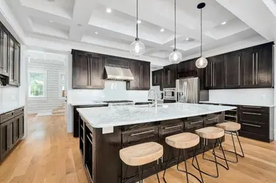a kitchen with wooden cabinets and a island with bar stools at St. Ivory in Rosemary Beach
