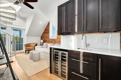 a kitchen with a sink and a living room at St. Ivory in Rosemary Beach