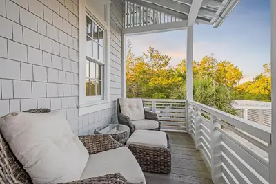 a porch with two chairs and a table at St. Ivory in Rosemary Beach