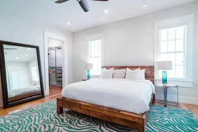 a bedroom with a large bed and a mirror at St. Ivory in Rosemary Beach