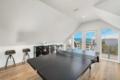 a black ping pong table in a room with a large window at Coastal Dream in Santa Rosa Beach