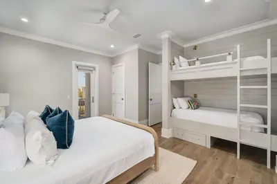 a white bedroom with two bunk beds in it at Coastal Dream in Santa Rosa Beach