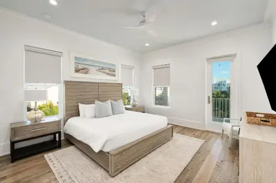 a white bedroom with a large bed and windows at Coastal Dream in Santa Rosa Beach