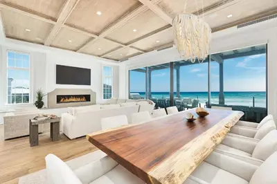 a living room with a table and a view of the ocean at Gulf Front Sanctuary in Santa Rosa Beach