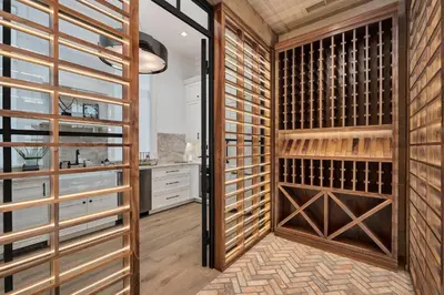 a wine cellar with wooden cabinets and a glass door at Gulf Front Sanctuary in Santa Rosa Beach