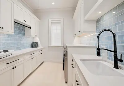 a white kitchen with a sink and a faucet at Gulf Front Sanctuary in Santa Rosa Beach