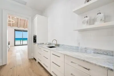 a white kitchen with a sink and a counter top at Gulf Front Sanctuary in Santa Rosa Beach