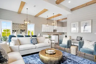 a living room with white furniture and blue chairs at Aces High in Santa Rosa Beach