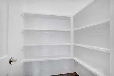 a walk in closet with white walls and shelves at Aces High in Santa Rosa Beach