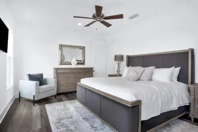 a bedroom with a bed with a ceiling fan and a chair at Aces High in Santa Rosa Beach