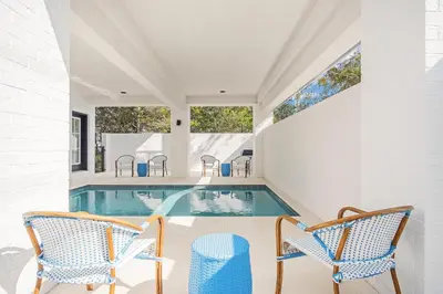a swimming pool in a house with two chairs at Aces High in Santa Rosa Beach