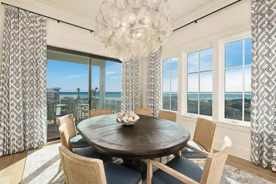 a dining room with a table and chairs and a chandelier at Emerald Le Luxe in Inlet Beach