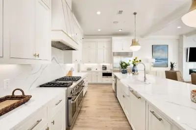 a kitchen with white cabinets and white counter tops at Emerald Le Luxe in Inlet Beach