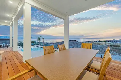 a dining room with a table and chairs on a deck at Emerald Le Luxe in Inlet Beach