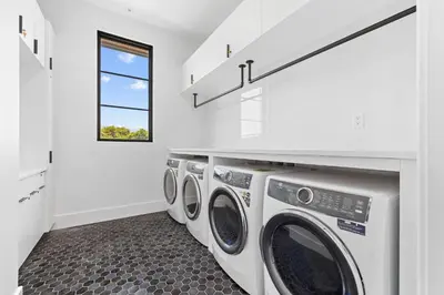 a laundry room with three washer and dryer at Above & Beyond in Santa Rosa Beach