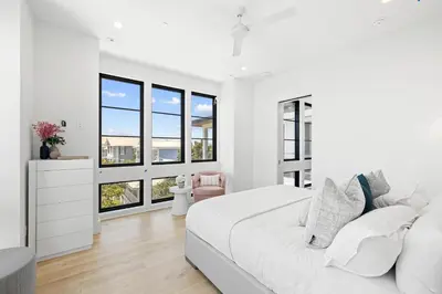 a white bedroom with a large bed and windows at Above & Beyond in Santa Rosa Beach