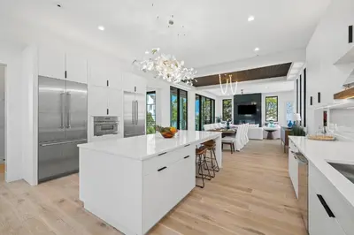 a kitchen with white cabinets and a dining room at Above & Beyond in Santa Rosa Beach