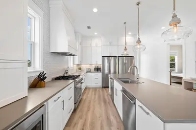a kitchen with white cabinets and stainless steel appliances at Idyll Time in Santa Rosa Beach