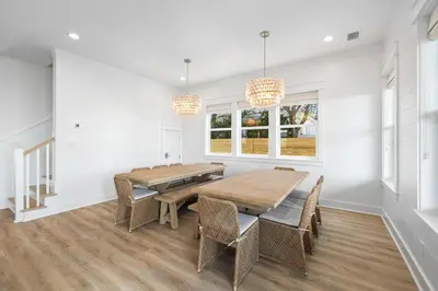a dining room with a wooden table and chairs at Idyll Time in Santa Rosa Beach