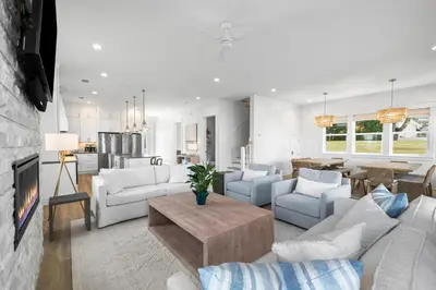 a living room with white furniture and a kitchen at Idyll Time in Santa Rosa Beach
