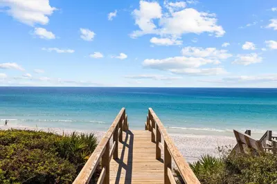 a wooden pathway to the beach with the ocean at Villa Grandeur in Santa Rosa Beach