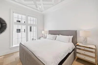 a white bedroom with a bed and a window at Villa Grandeur in Santa Rosa Beach