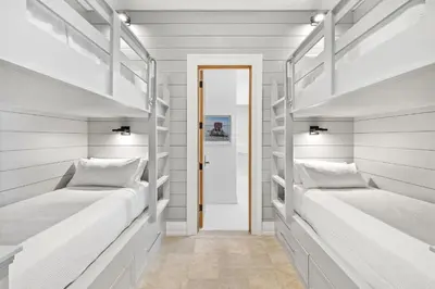 two bunk beds in a room with white walls at Villa Grandeur in Santa Rosa Beach