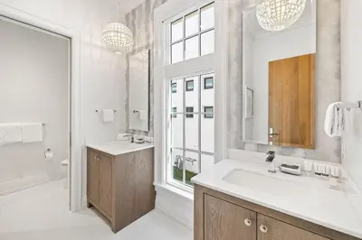 a white bathroom with a sink and a mirror at Villa Grandeur in Santa Rosa Beach