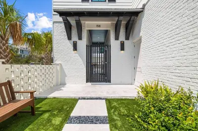 a entrance to a white brick house with a gate at Seven Palms Reunion in Inlet Beach
