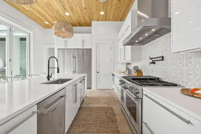 a kitchen with white appliances and a wooden ceiling at Seven Palms Reunion in Inlet Beach