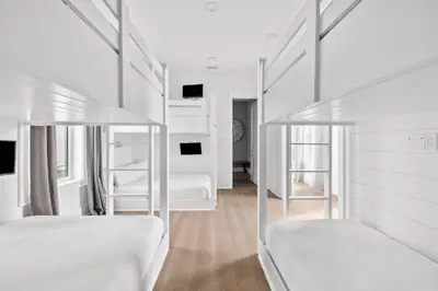 a white bedroom with two beds and a mirror at Seven Palms Reunion in Inlet Beach