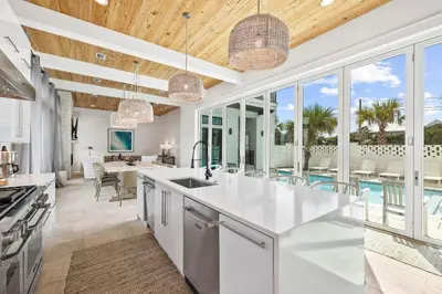 an open kitchen with white countertops and glass windows at Seven Palms Reunion in Inlet Beach