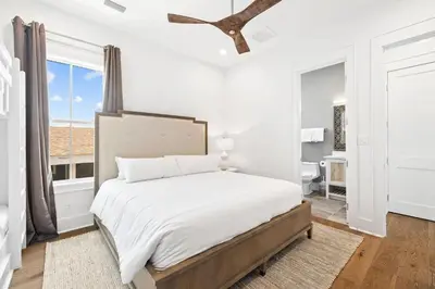 a white bedroom with a large bed and a window at Bullish On Beaches in Inlet Beach