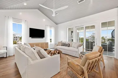a living room with white furniture and a flat screen tv at Bullish On Beaches in Inlet Beach