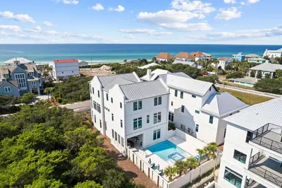 an aerial view of a white house and the ocean at Seven Palms Retreat in Inlet Beach